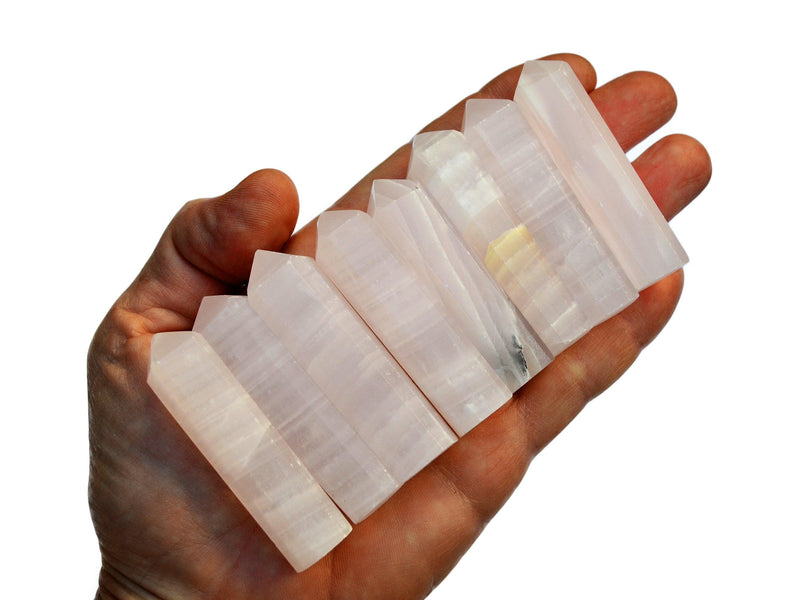 Eight pink mangano calcite crystal points 55mm-60mm on hand with white background