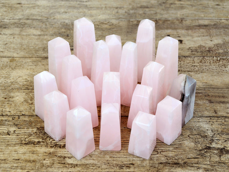 Several mangano calcite obelisks 60mm-95mm on wood table