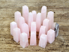 Several mangano calcite obelisks 60mm-95mm on wood table