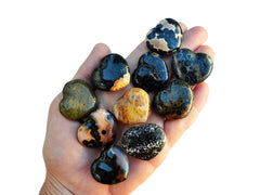 Ten colorful ocean jasper crystal hearts 30mm o n hand with white background