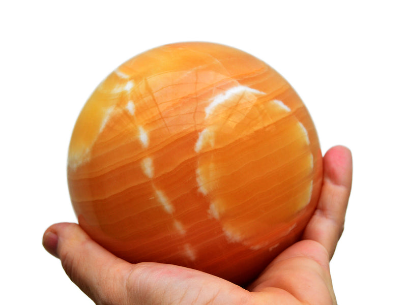 Extra large calcite sphere crystal on hand with white background