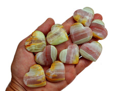 Ten pink banded onyx small hearts 25mm-35mm on hand with white background