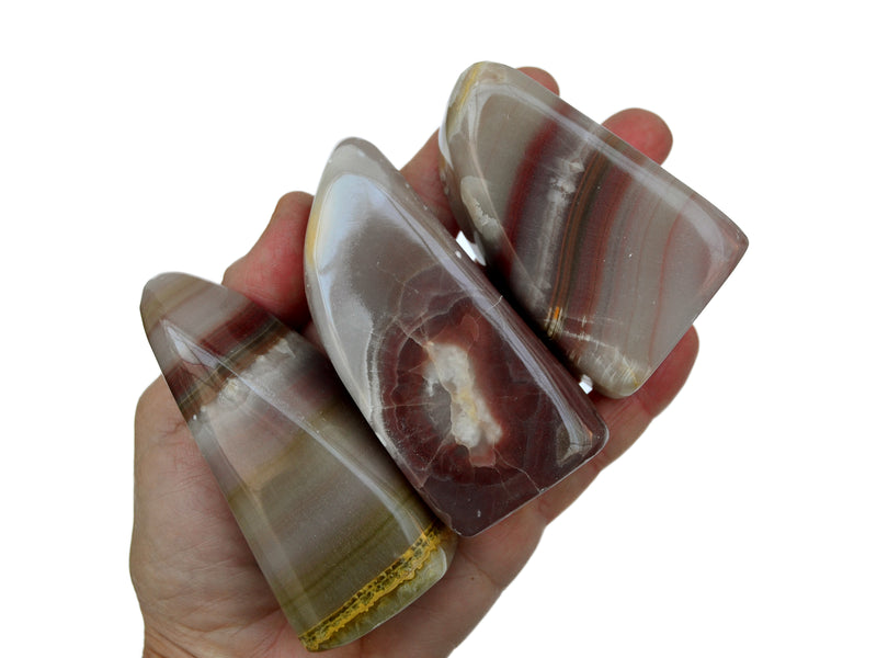 Three pink banded onyx 60mm on hand with white background