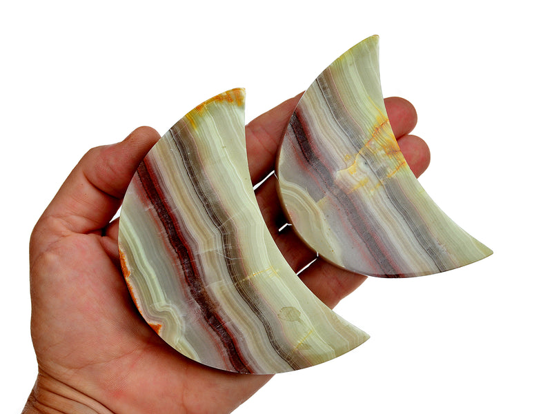 Two pink banded onyx moon shapped crystals 90mm-100mm on hand with white background