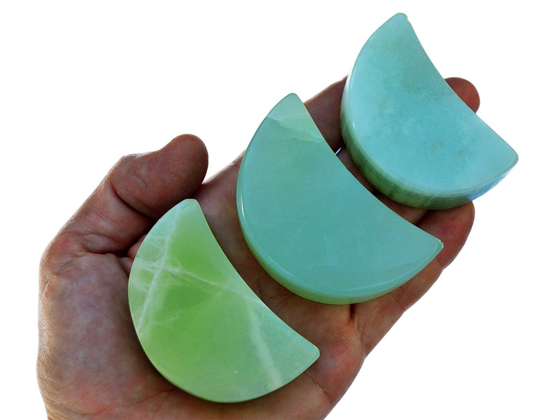 Three gren pistachio calcite moon shapped crystals 60mm on hand with white background