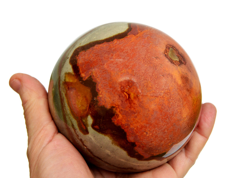 Extra large desert jasper sphere crystal 95mm on hand with white background