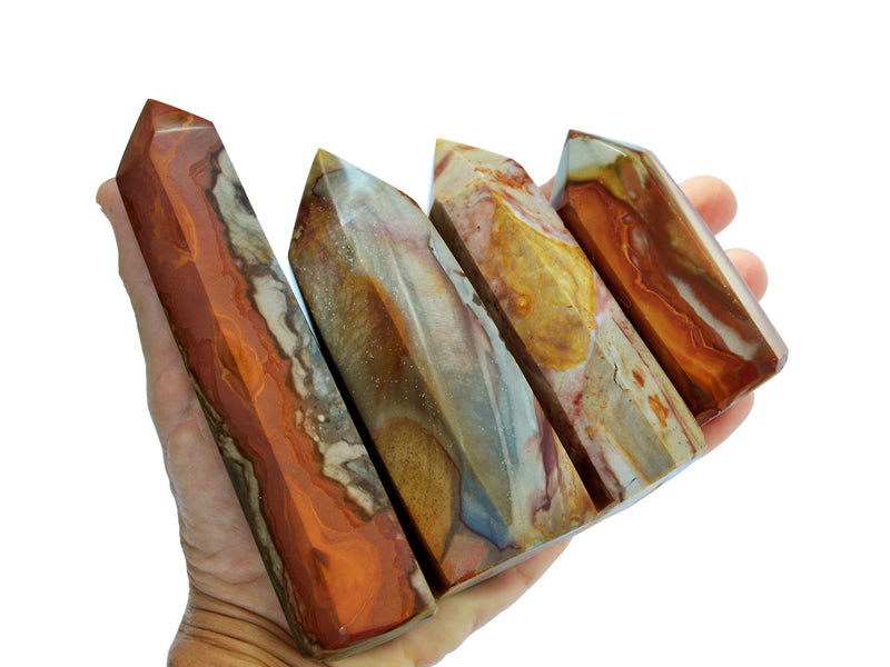 Four polychrome jasper towers on hand with white background