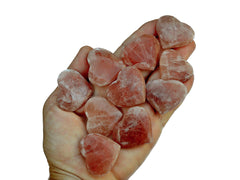 Ten rose calcite hearts 30mm-40mm on hand with background with white background
