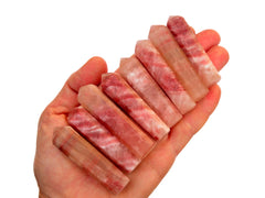 Eight rose calcite faceted points 55mm-65mm on hand with white background