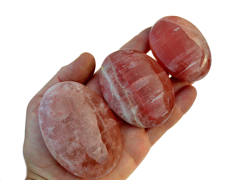 Three rose calcite palm stones 50mm-70mm on hand with white background