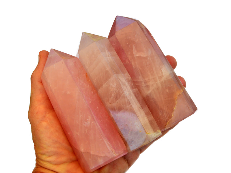 Three rose quartz towers 110mm on hand with white background