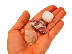 Raw pink quartz, raw pink tourmaline and mangano calcite tumbled 30mm-40mm on hand with white background