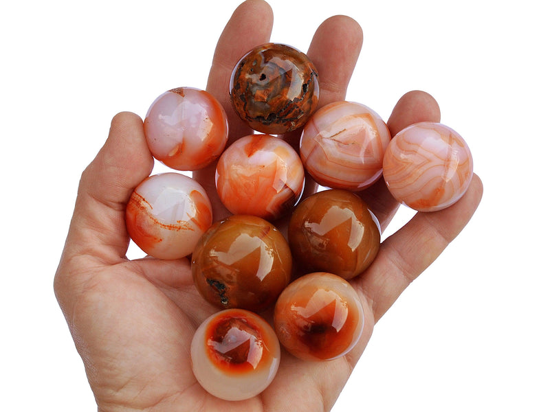 Several carnelian crystal balls 25mm-40mm on hand with white background