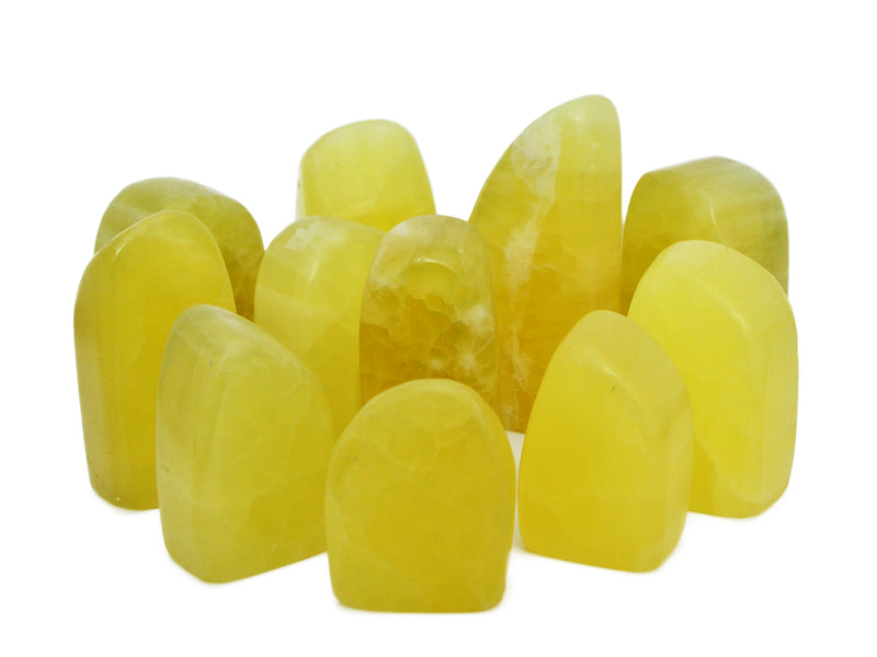 Several yellow calcite free form stones on white background