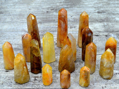 Several golden healer quartz points 50mm-130mm on wood table