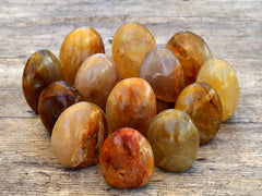 Several golden healer quartz free form minerals on wood table