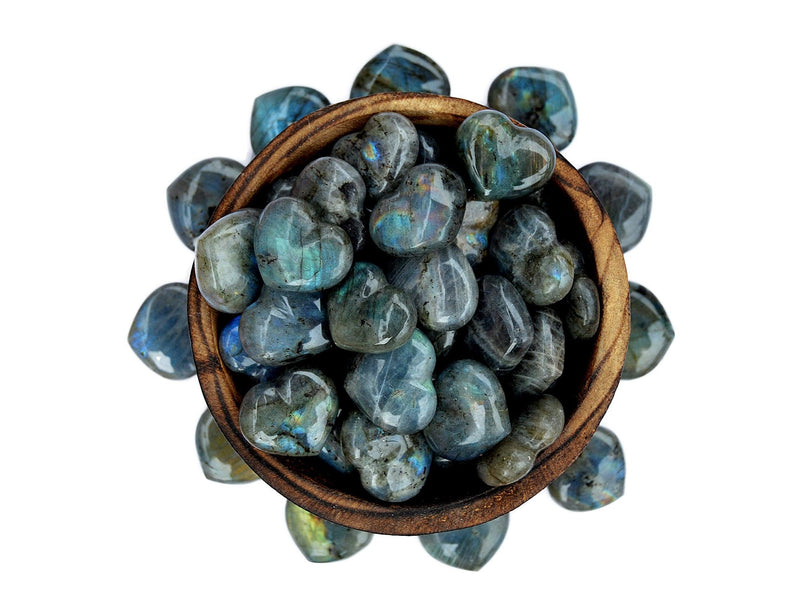 Several labradorite puffy heart crystals 30mm inside a bowl with some stones outside forming a circle around