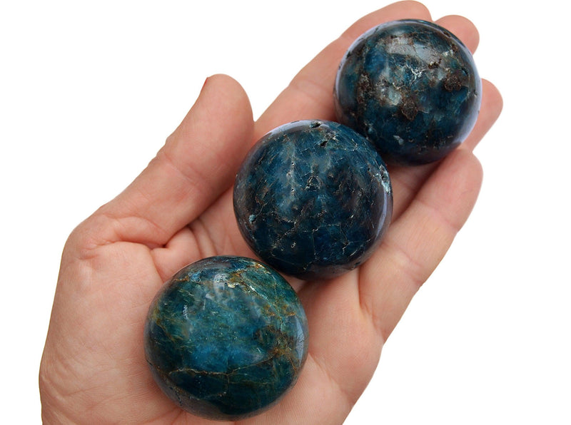 Three blue apatite crystal sphere stones 40mm on hand 