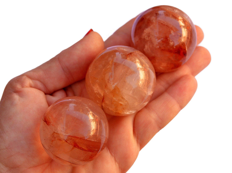 Three fire quartz sphere crystals 35mm-40mm on hand with white background 