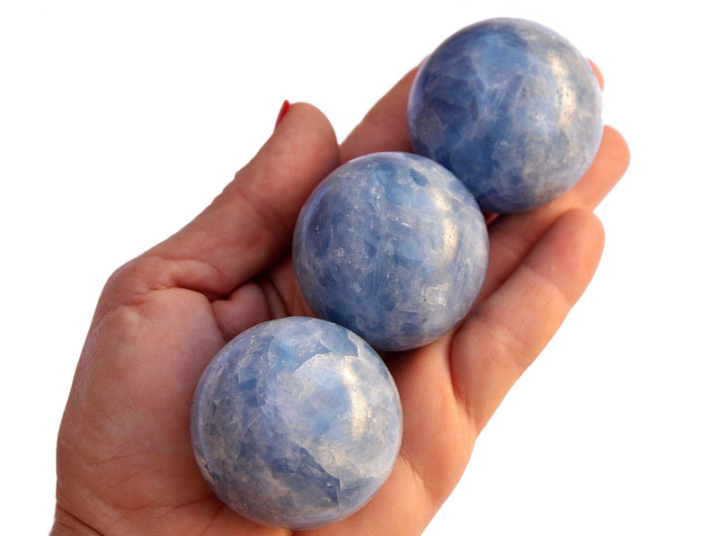 Three blue calcite mineral spheres 40mm on hand