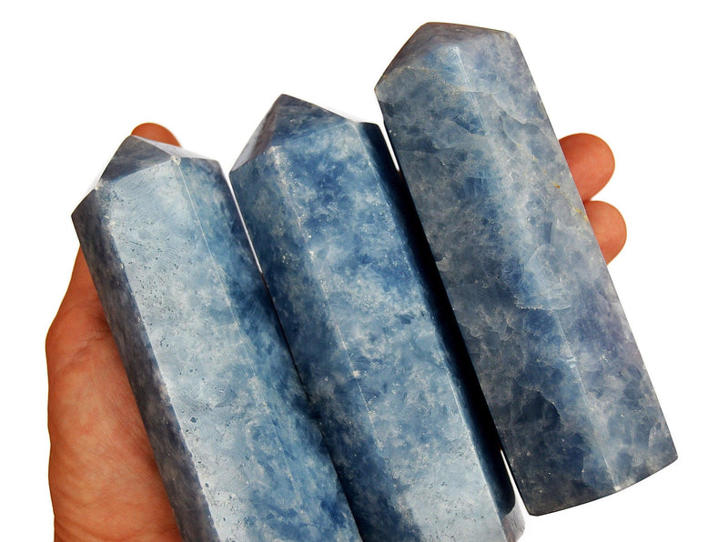 Three blue calcite crystal towers 110mm on hand with white background