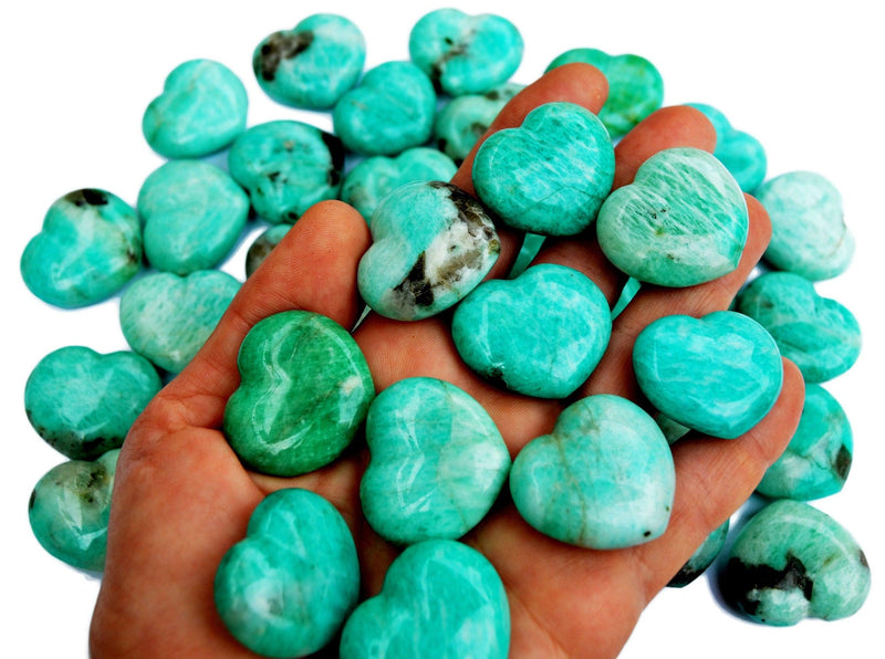 Some amazonite crystal hearts 30mm on hand with background with several hearts 