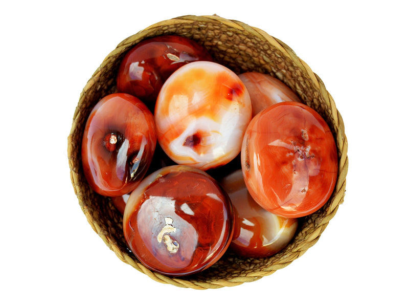 Several carnelian palm stones 40mm-70mm inside a basket on white background