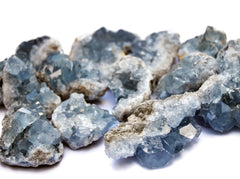 Several blue celestite crystal clusters on white background 
