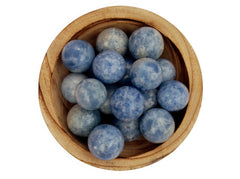 Several blue calcite sphere crystals 25mm-40mm inside a wood bowl on white background