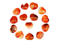 Several carnelian crystal hearts 30mm forming a circle on white background