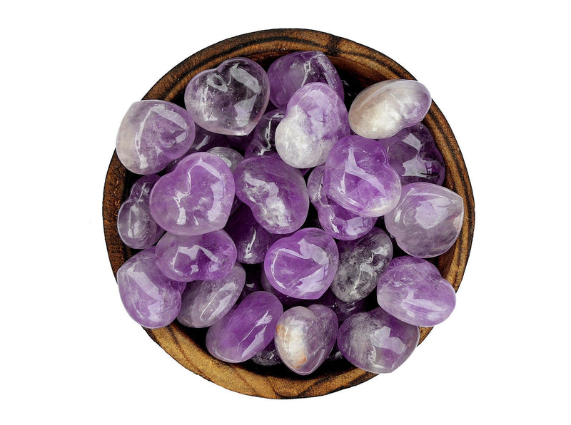 Several amethyst crystal hearts 30mm inside a bowl on white background