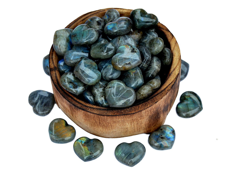 Several labradorite puffy heart crystals 30mm inside a bowl with some stones outside around