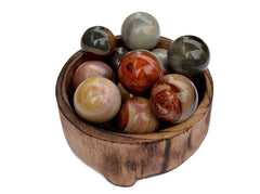 Several multicolor desert jasper sphere balls 25mm - 40mm inside a wood bowl