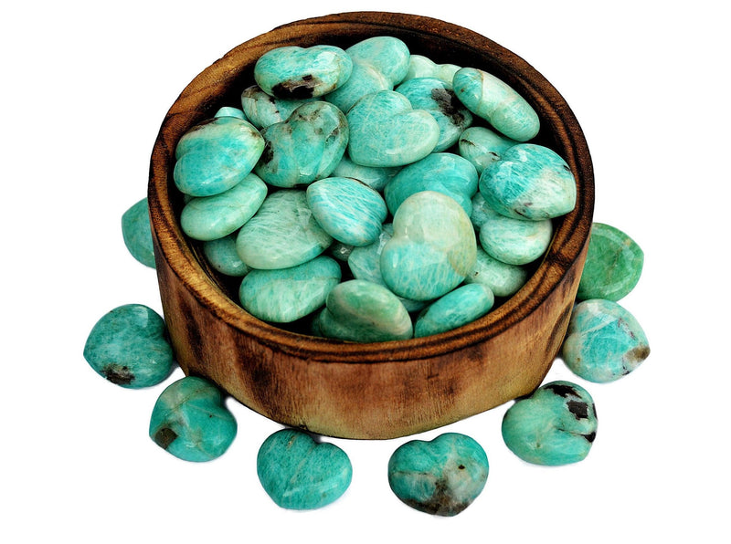 Several small green amazonite puffy crystal hearts 30mm inside and outside from wood bowl on white background