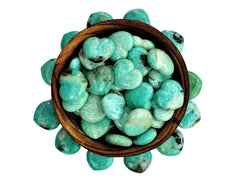Several amazonite stone hearts 30mm inside a bowl with some crystals around on white background