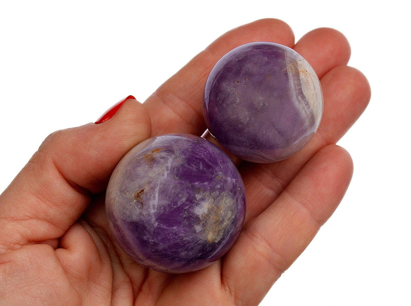 Two small amethyst spheres on hand