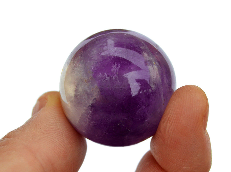 One amethyst sphere 35mm on hand with white background