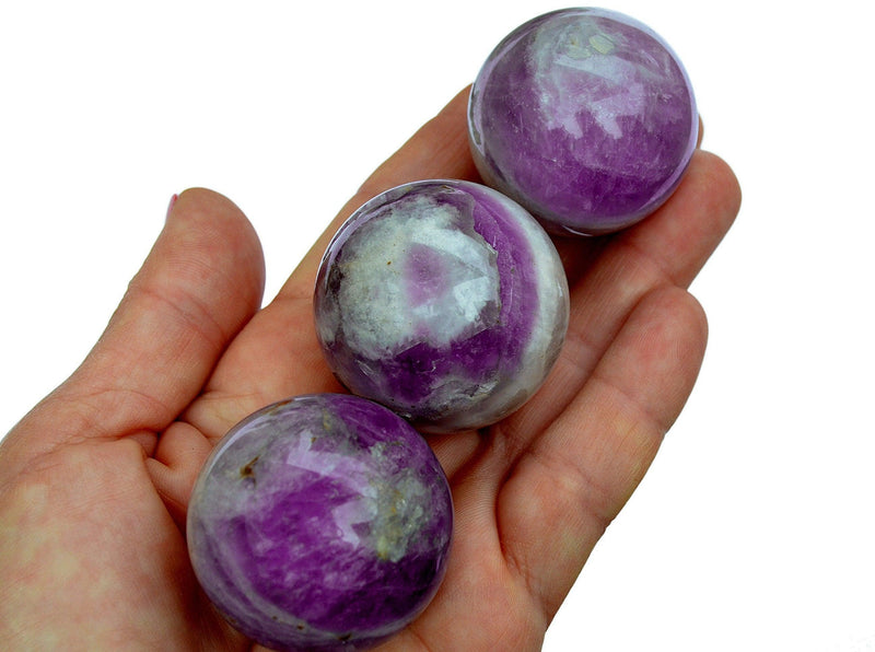 Three amethyst sphere stones 45mm-50mm on hand with white background