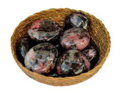 Some rhodonite palm stones inside a basket