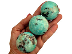 Three  green amazonite spheres 45mm on hand with white background