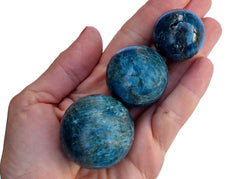 Three blue apatite crystal spheres 40mm - -25mm on hand 