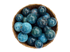 Several blue apatite sphere crystals 25mm-40mm inside a basket on white background