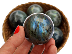 One blue labradorite sphere 50mm on hand with white background