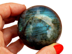 One blue labradorite sphere crystal 60mm on hand with white background
