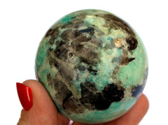 Green amazonite crystal ball 60mm on hand with white background