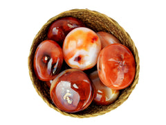 Several carnelian palm stones 40mm-70mm inside a basket on white background