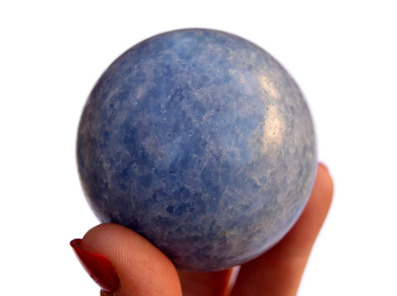One blue calcite sphere mineral 60mm on hand with white background
