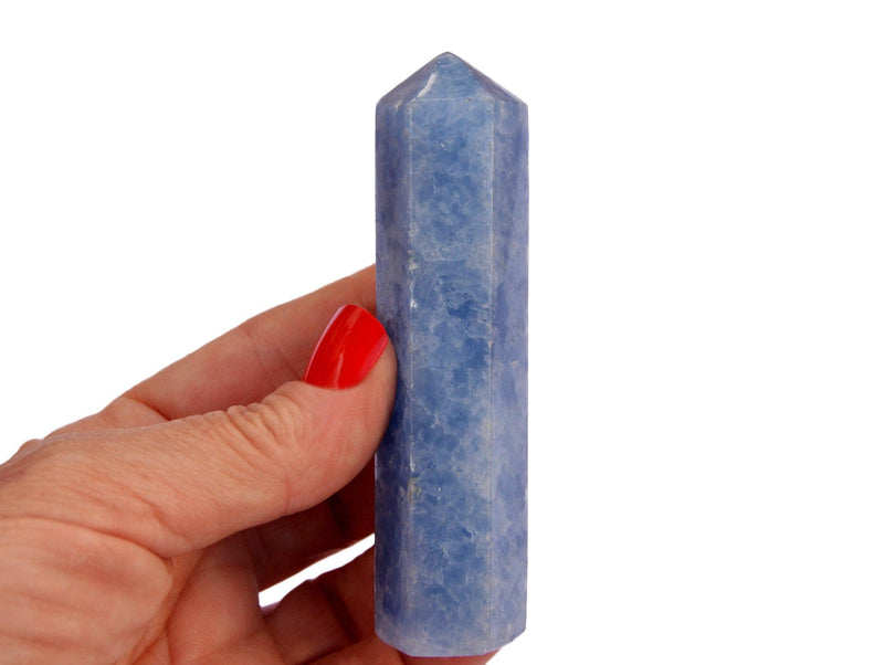 One blue calcite tower crystal 90mm on hand with white background