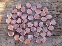 Several rose quartz puffy heart stones 30mm on wood table