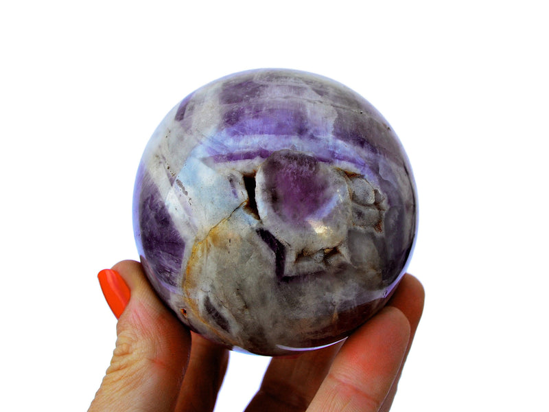 Big amethyst crystal sphere 70mm on hand withwhite background